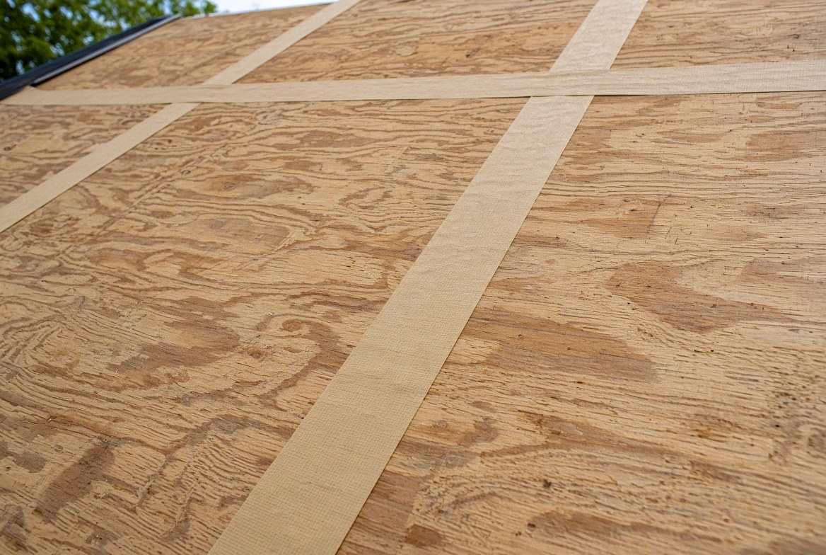 Plywood roof sheathing joints covered with wide seam tape